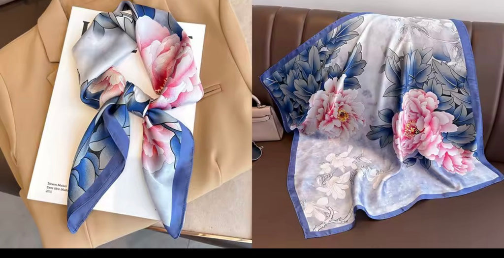 Foulard satiné imprimé pivoines bleu et rose posé sur une veste beige